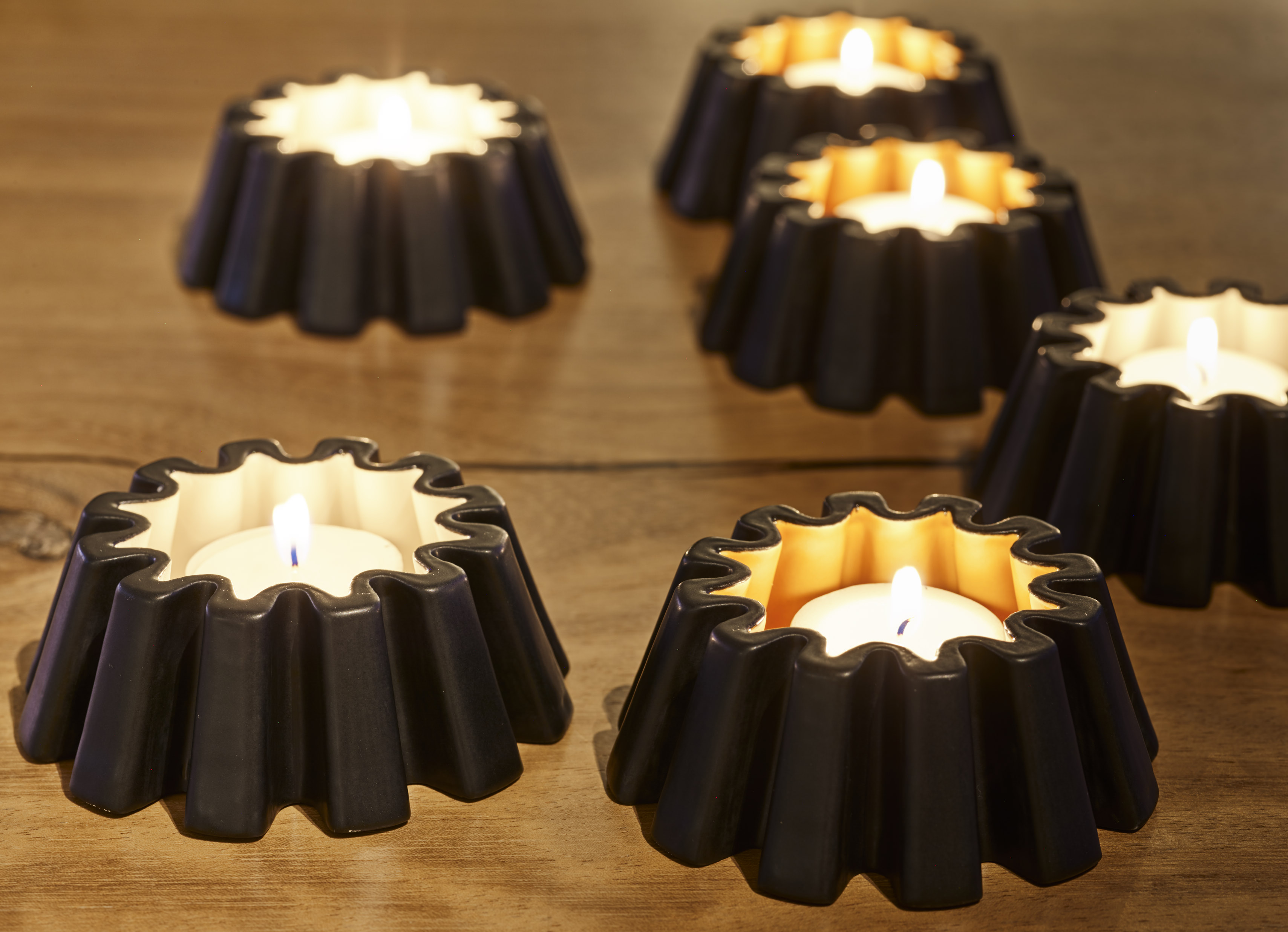 Candle Light Gear — fluted black tealights with warm flames on oak