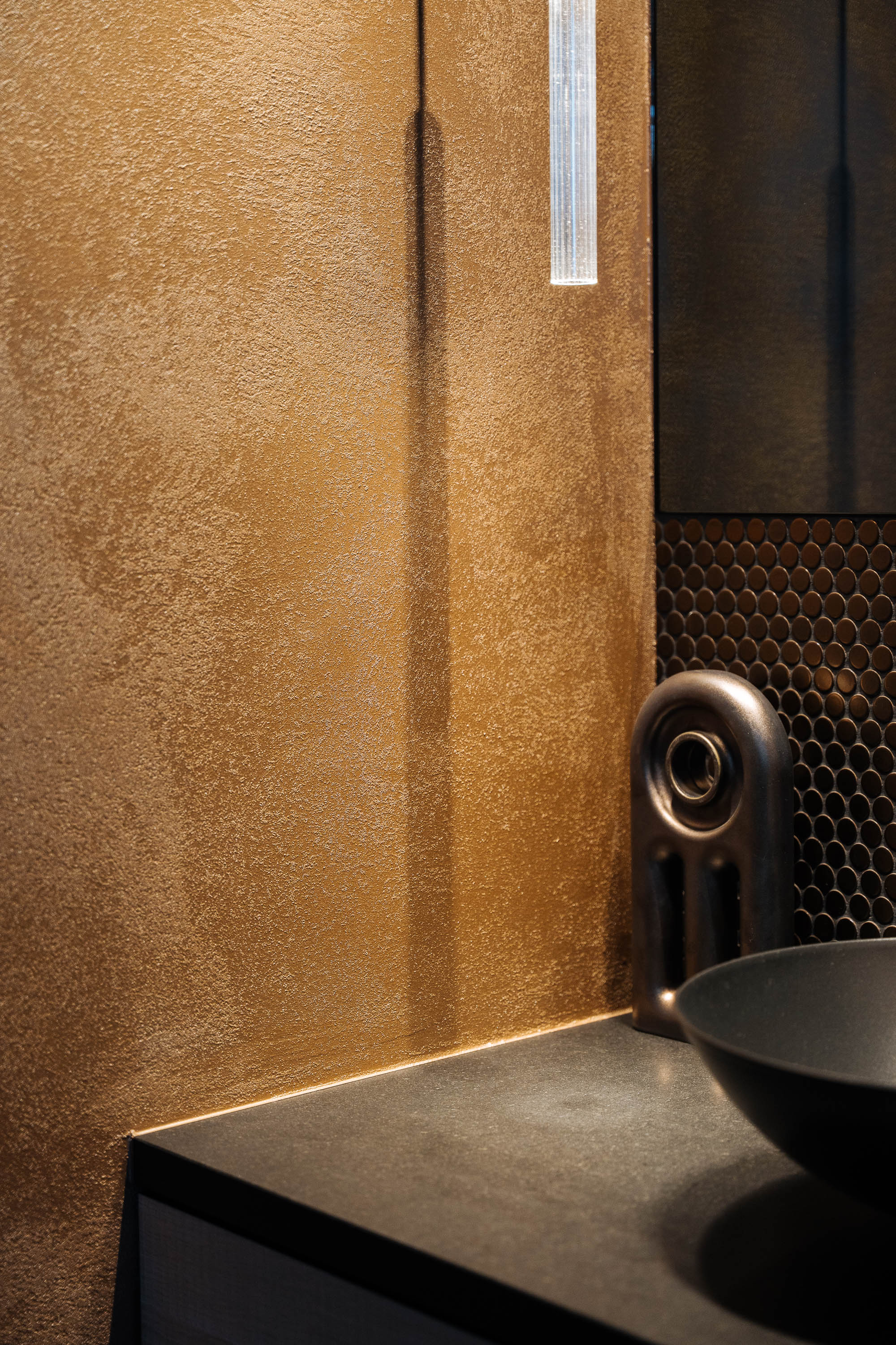 Bath detail in gold and bronze with ceramic vessel tap