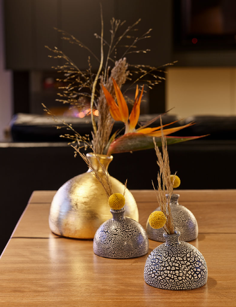 Slipcast vases — orange glazed vessel with rosehip branches
